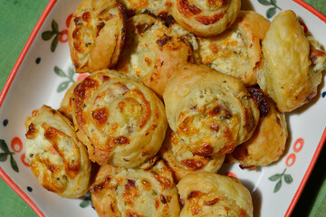 Plate with puff pastry rolls with cheese and ham