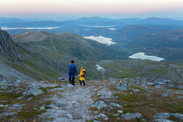 Fototapeta premium Children and adults, family with dog, hiking Grytetippen trail in Senja, Lofoten on a sunny summer day