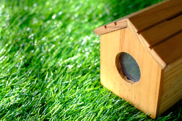 Wooden house on green leave background.
