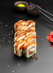 Canada roll with an eel on a black background