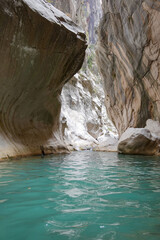A narrow canyon with a river running through it