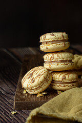 Light brown, beige french macaroons  on dark brown background 