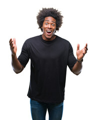 Fototapeta premium Afro american man over isolated background celebrating crazy and amazed for success with arms raised and open eyes screaming excited. Winner concept