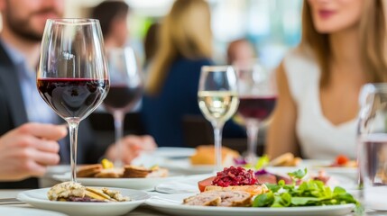 Obraz premium The top of a table is topped with a bowl of salad and a glass of wine along with a table of food and dishes.