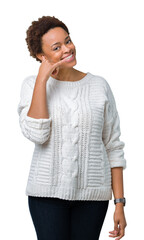 Beautiful young african american woman wearing sweater over isolated background smiling doing phone gesture with hand and fingers like talking on the telephone. Communicating concepts.