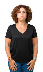 Fototapeta premium Beautiful middle ager senior woman over isolated background puffing cheeks with funny face. Mouth inflated with air, crazy expression.