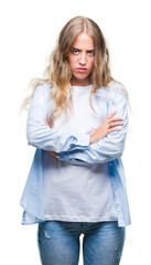 Beautiful young blonde woman over isolated background skeptic and nervous, disapproving expression on face with crossed arms. Negative person.
