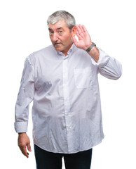 Handsome senior man over isolated background smiling with hand over ear listening an hearing to rumor or gossip. Deafness concept.