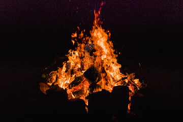 Close-up fire, large burning blocks of wood and flames of red fire at the summer solstice	