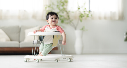 歩行器を使って歩く生後10ヶ月の男の子