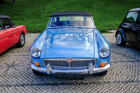 Vintage sky blue MGC roadster car on cobblestone path