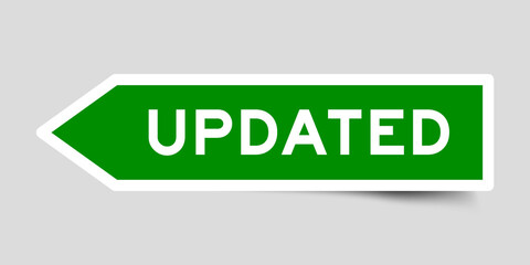 Green color arrow shape sticker label with word updated on gray background