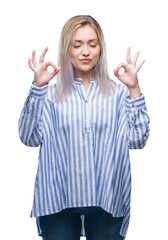 Young blonde woman over isolated background relax and smiling with eyes closed doing meditation gesture with fingers. Yoga concept.