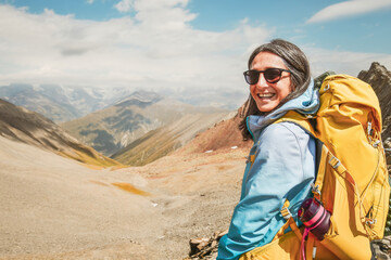 Naklejka premium Close up Young woman guide portrait hiking mountains - Happy hiker on the top of the cliff smiling at camera - Travel and hobby concept