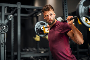 A determined young adult man lifting weight at the gym