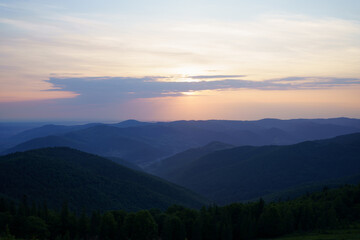 Fototapeta premium View of the dawn and the blue sky with the sun shining on the mountains. Image for your design and space for your text. The concept of hiking, outdoor recreation, biodiversity conservation