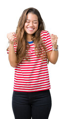 Young beautiful brunette woman wearing stripes t-shirt over isolated background excited for success...