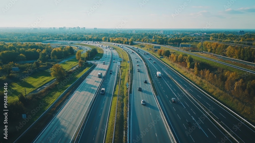 Poster wide-angle view of a busy motorway with multiple lanes, capturing the flow of traffic and the surrou