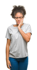 Young afro american woman wearing glasses over isolated background touching mouth with hand with painful expression because of toothache or dental illness on teeth. Dentist concept.