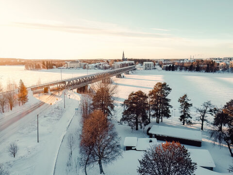 Aerial view of frozen river through Rovaniemi with bridge in Lapland