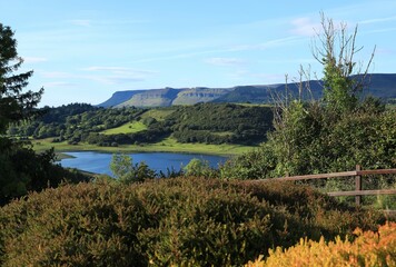 Landscape in rural County Sligo, Ireland in Autumn featuring Benbulben Mountain and nearby hills viewed from garden shrubbery across Lough Colgagh 