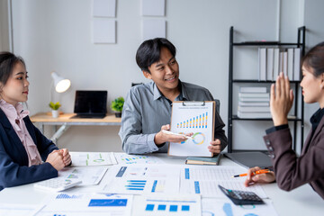 Asian business team discussing financial charts and data analysis