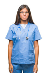 Young asian doctor woman over isolated background with serious expression on face. Simple and natural looking at the camera.