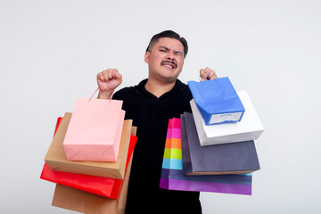 A tired middle-aged man annoyed at carrying multiple shopping bags bought by his wife. Isolated on...