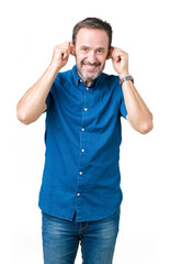 Fototapeta premium Handsome middle age elegant senior man over isolated background Smiling pulling ears with fingers, funny gesture. Audition problem