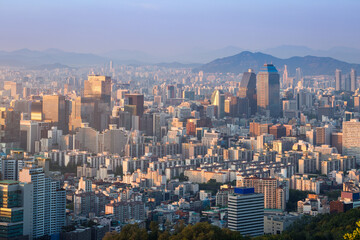 Seoul city and skyscrapers in Gangnam district in the afternoon, with light fog and Bukhansan Mountain in the background, Seoul, South Korea.