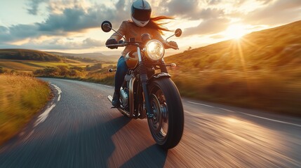 Naklejka premium A female motorcyclist is riding on a curving road during sunset, capturing the thrill and freedom of the open road.