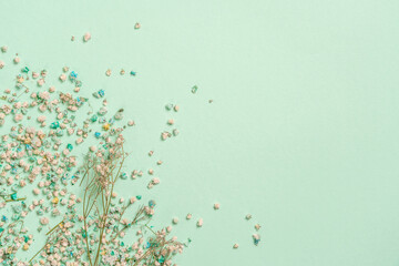 Decoration with gypsophila flowers with copy space on light green background, flat lay