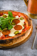 Top view of Neapolitan pizza with sausage, jalapeno peppers and arugula