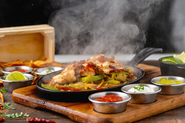 Shrimp fajitas on wooden table with sauces and tortillas on the side