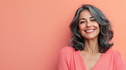 Fototapeta premium A woman with a pink shirt and gray hair is smiling