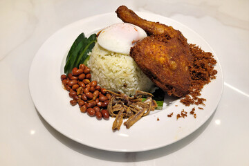 Nasi lemak set with ayam goreng, a traditional Malay rice dish cooked in coconut milk and served...