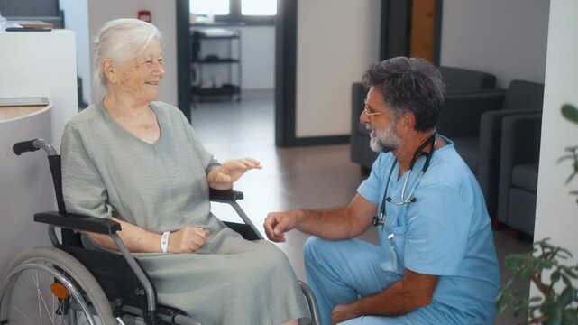 Friendly doctor high fives with disabled patient 80s old grandmother in wheelchair, providing medical assistance or care in geriatrics