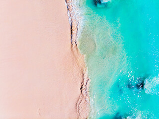 Beautiful tropical beach scene with soft white sand, and clear turquoise water with waves