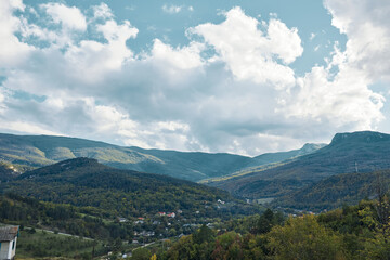 Scenic mountain valley landscape with house and majestic mountains in background, ideal for travel and outdoor adventure promotions