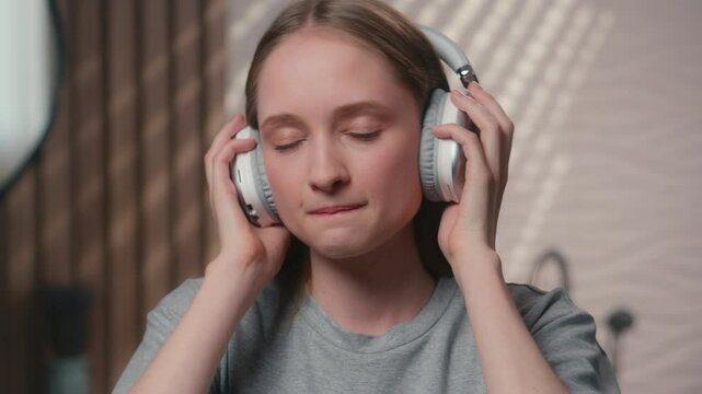 Caucasian woman smiling homeowner female carefree happy girl lady in bathroom wear headphones listen audio music dance relax home bath enjoy song in wireless earphones listening sound rhythm dancing
