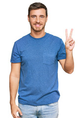 Naklejka premium Handsome caucasian man wearing casual clothes showing and pointing up with fingers number two while smiling confident and happy.
