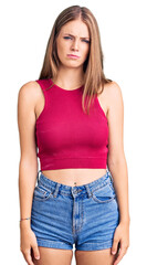 Young beautiful blonde woman wearing elegant summer shirt skeptic and nervous, frowning upset...