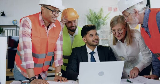 Man and woman team of construction specialists previsioning building project on laptop together.