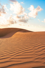 Desert landscape with warm orange sand dunes and sunset