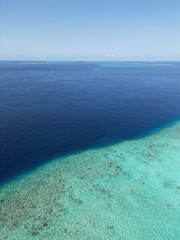 This image captures a breathtaking aerial view of a small, circular sandbank in the Maldives. 