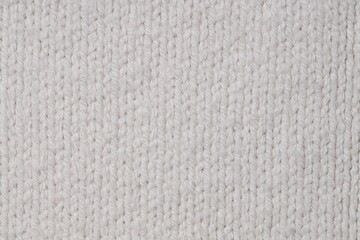 Texture of white knitted fabric with pattern as background, top view