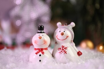 Funny snowmen figures on artificial snow, closeup