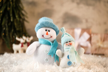 Funny snowmen figures on artificial snow, closeup
