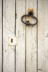Rustic wooden door with vintage metal handle and weathered paint