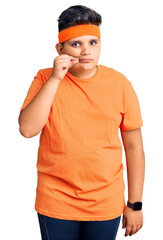 Little boy kid wearing sportswear mouth and lips shut as zip with fingers. secret and silent, taboo...
